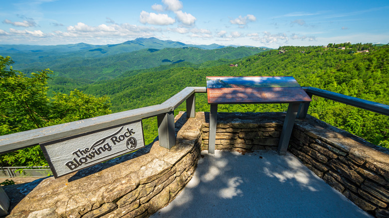 The Blowing Rock overlook with forested green hills in the background