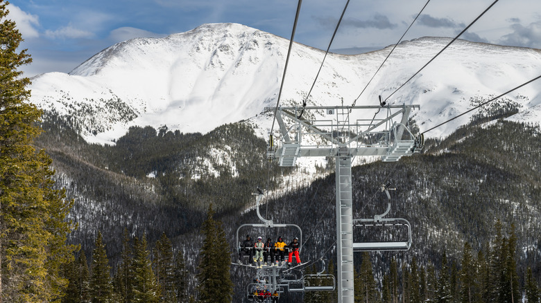 A ski lift in Winter Park, Colorado with snowcapped peaks in the background