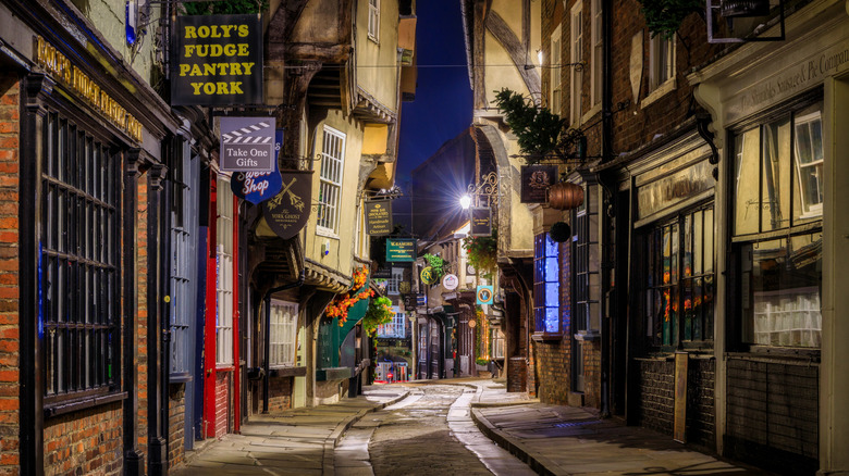 cobbled street at nighttime lined with old stores