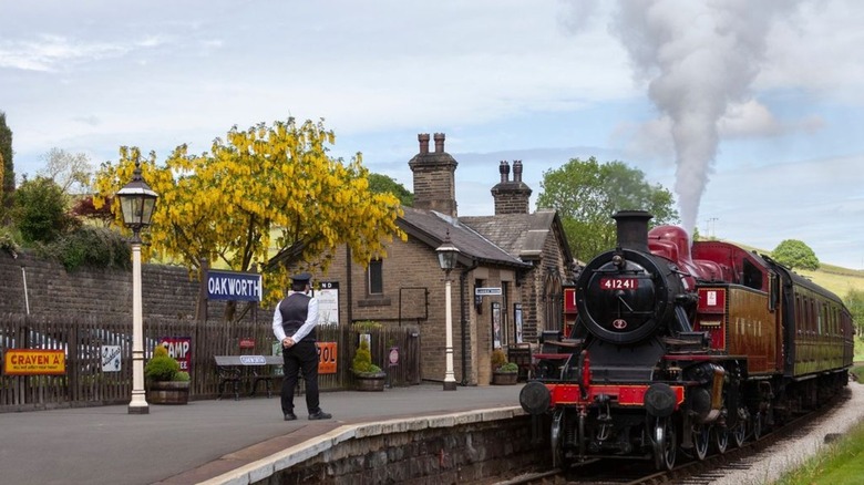 steam train pulling into rural station