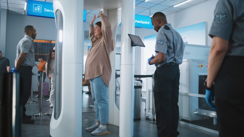 woman going through TSA scanner