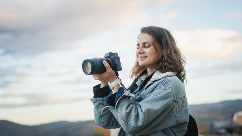 A photographer smiles at a photo she just took