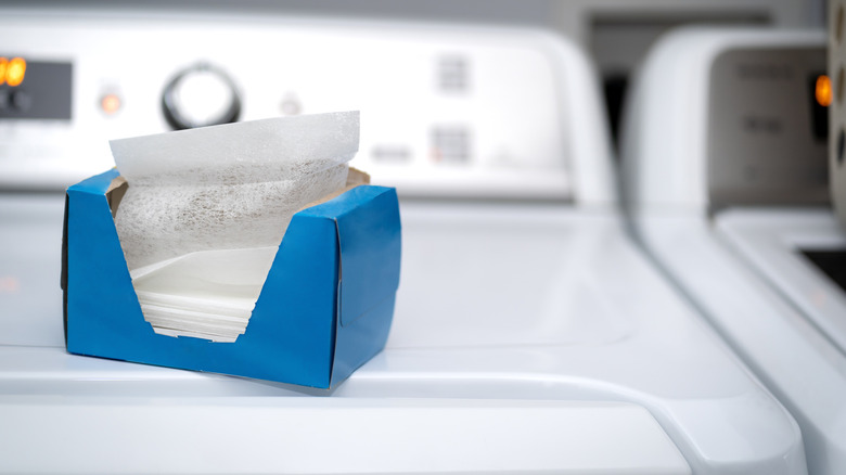 A box of dryer sheets sitting on top of a washing machine.