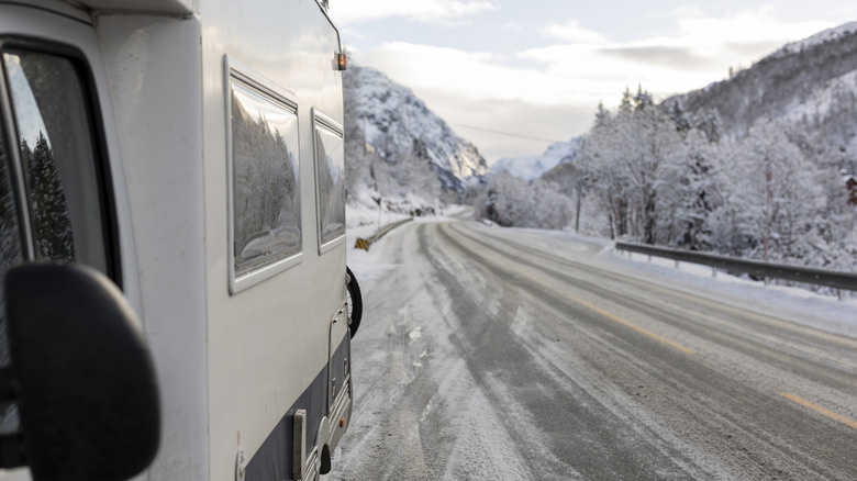 side of camper van shown on side of snowy road