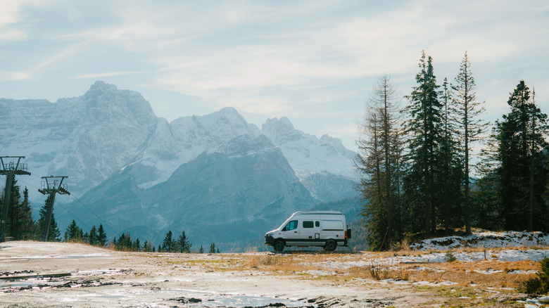 camper van in distance with winter mountain scenery