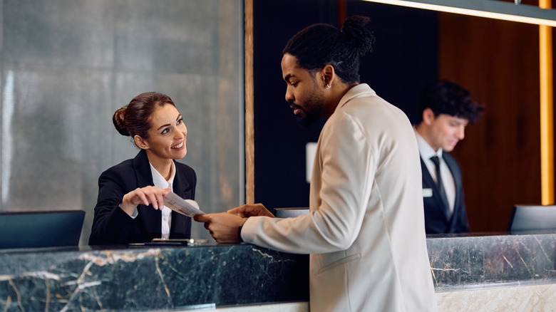 A hotel guest speaking with a front desk representative.