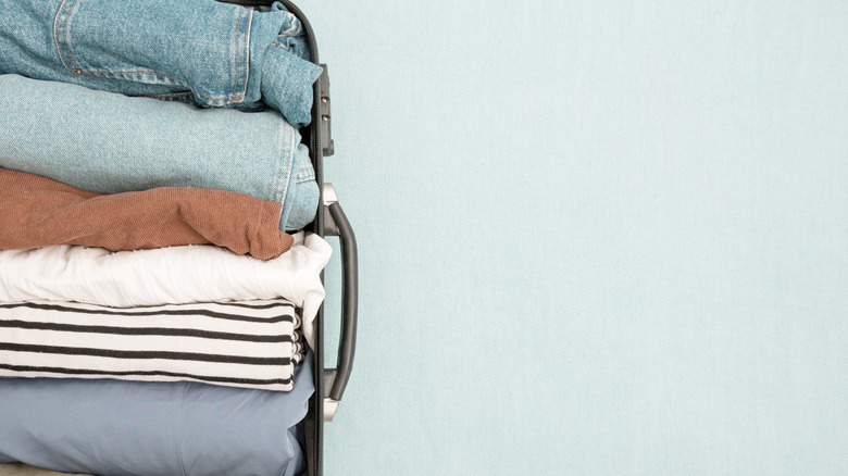 An open suitcase with neatly folded clothes vertically stacked