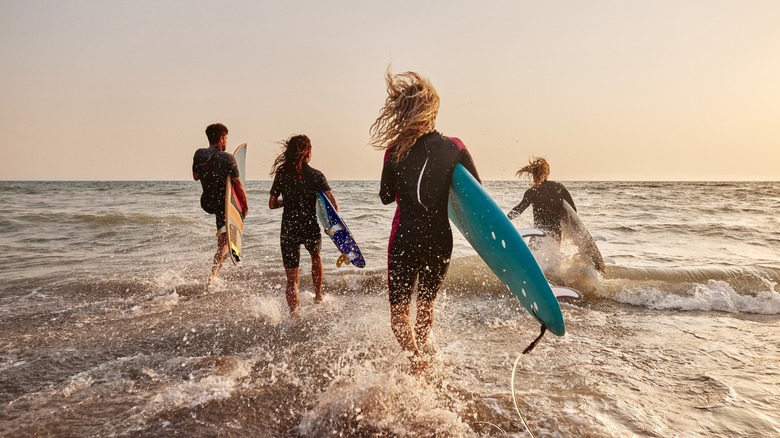 surfers running into the ocean