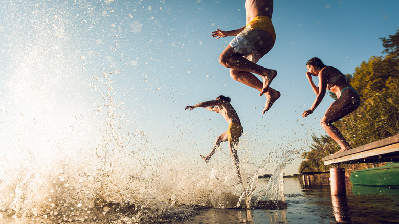 People jumping into a lake