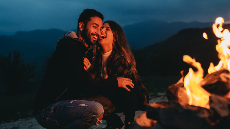 Young couple embracing near a campfire