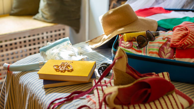 A suitcase overflowing with summer themed items
