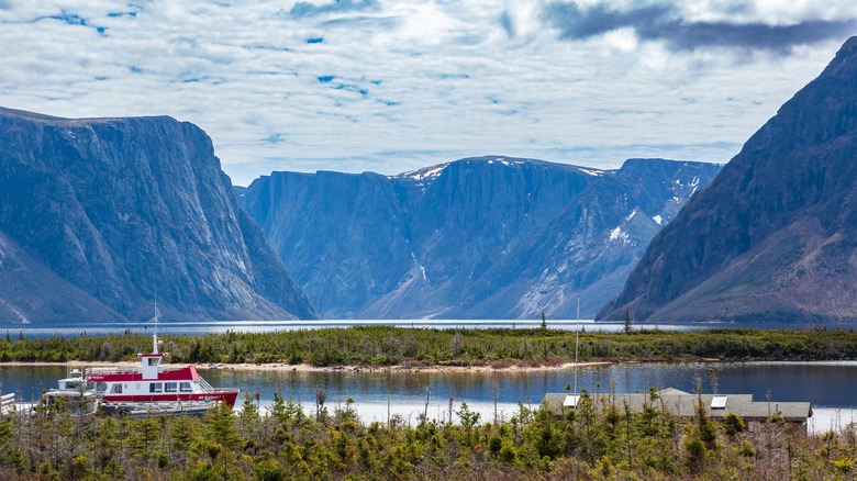A boat on the water with mountains in the background