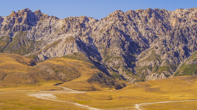 Stunning landscape with yellow meadows and rocky mountains in Campo Imperatore valley, Gran Sasso National Park, Abruzzo region, Italy