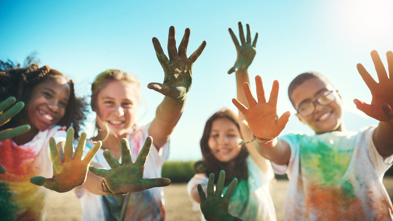 Happy kids at a summer camp with dirty painted hands
