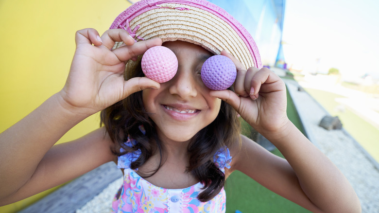 Little girl holding golf balls