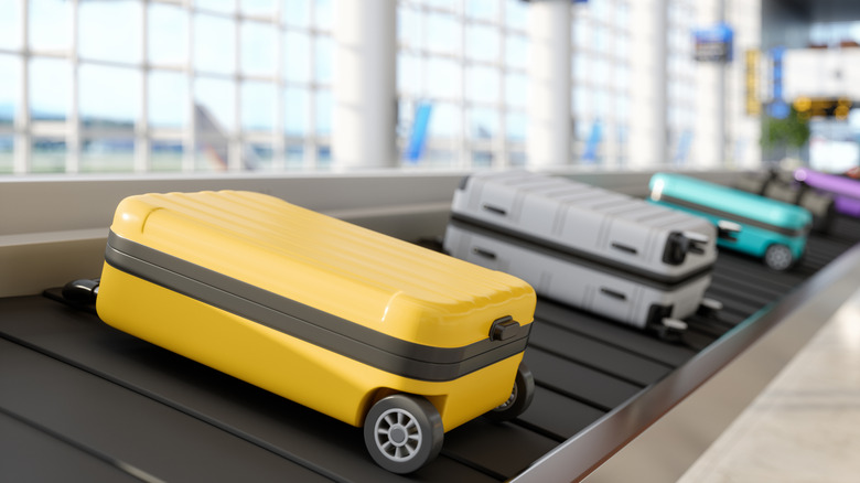 A row of luggage seen on a conveyor belt in an airport