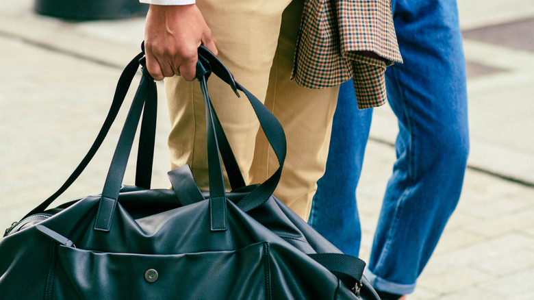 men in suits holding duffel