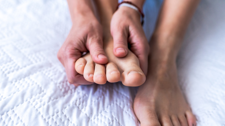 Hands massaging bare feet