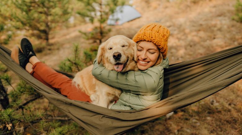 woman with dog in hammock