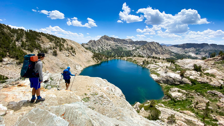 Two hikers walk down to an alpine lake in front of Ruby Mountain in Humboldt-Toiyabe National Forest Nevada