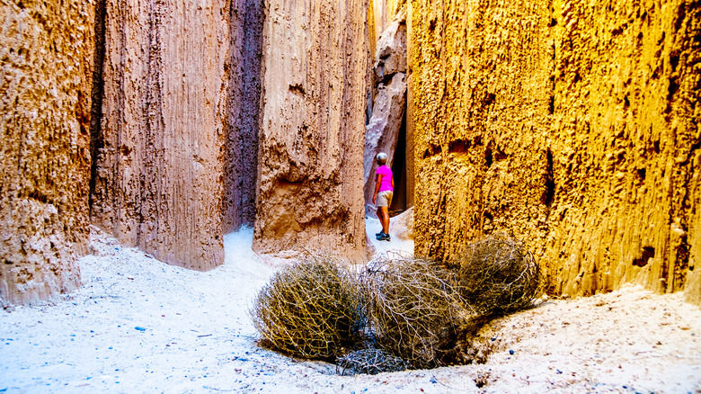 Woman hiking through a slot canyon