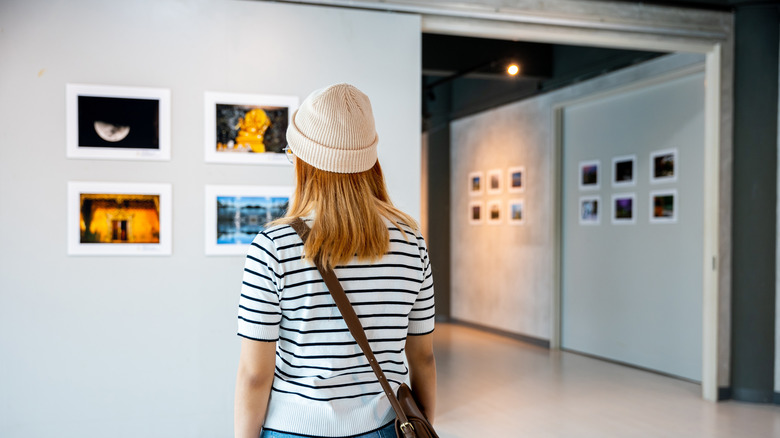 A woman looking at local art in a gallery.