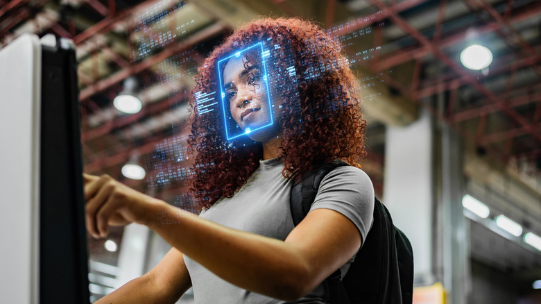 A woman operating a facial recognition device