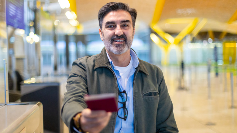 Man handing over passport at border control