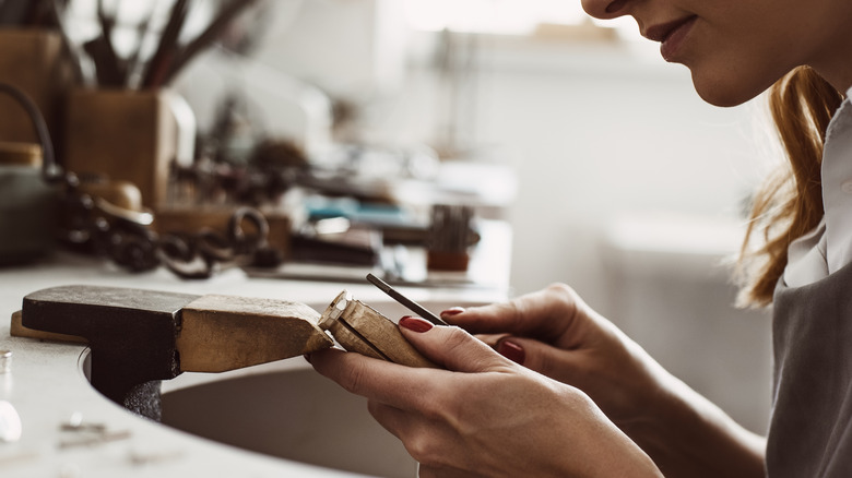 a woman working with jewelry making tools