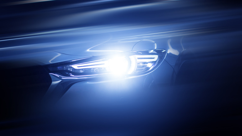 A bright car headlight in a dark area