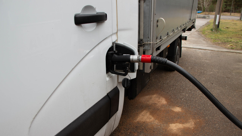 black fuel nozzle inserted into a white van