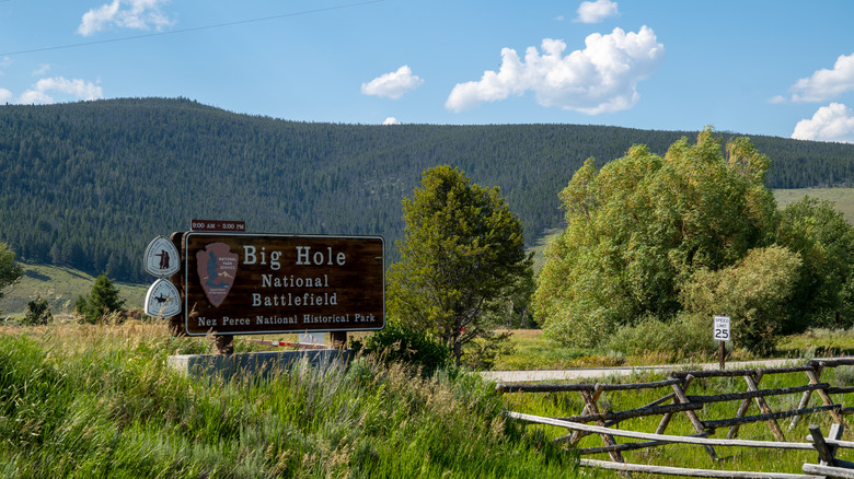 Sign for the Big Hole National Battlefield, with green hill in background