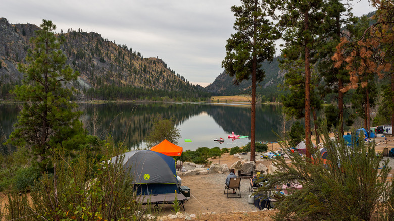 camping by lake with trees and mountains