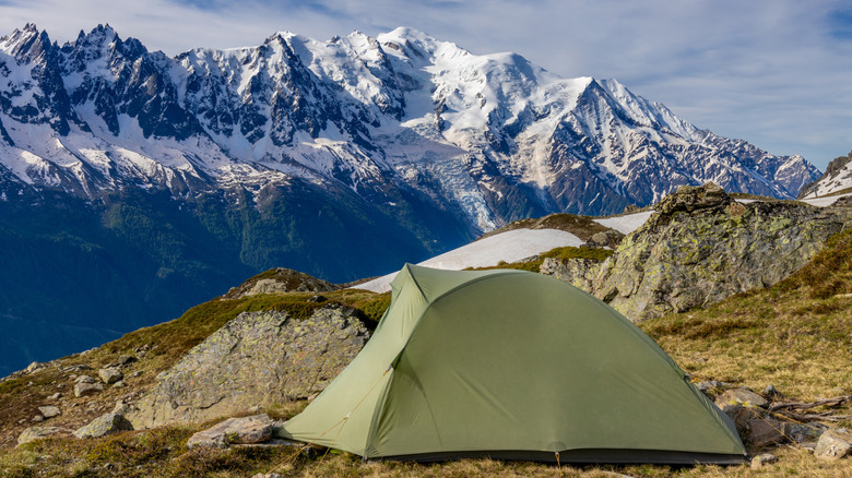 Tent on rocks overlooking mountains
