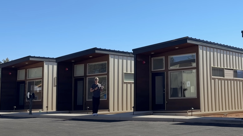 Person standing in front of three tiny homes