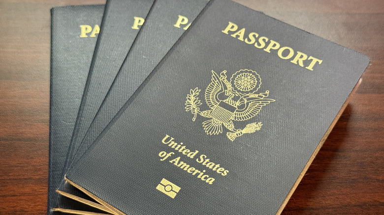 Four US passports fanned out on a table.