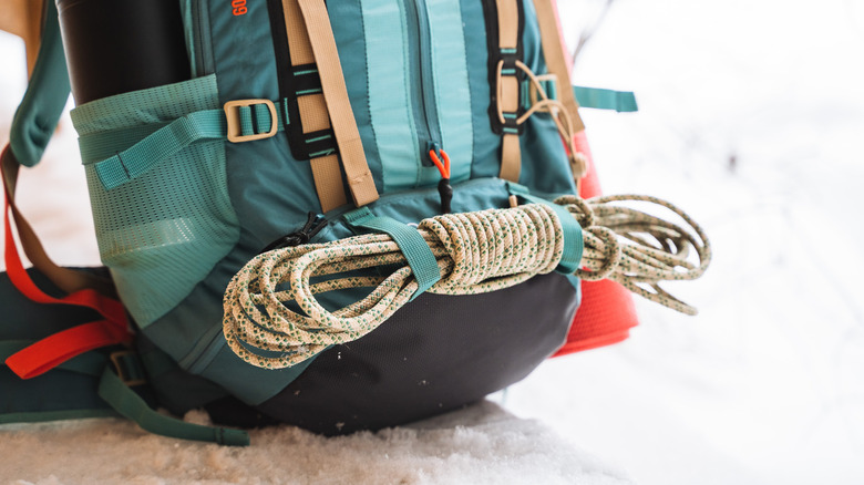 A well rolled rope is affixed to a backpack