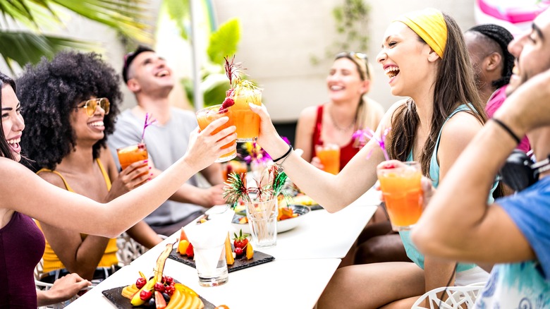 Laughing friends holding drinks