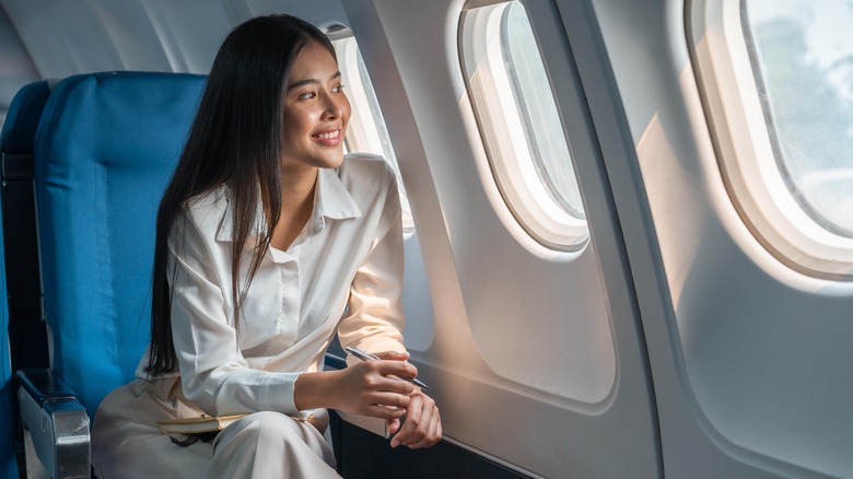 Woman sitting on airplane smiling