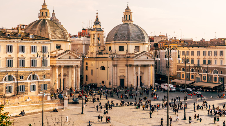 Old Roman buildings and pedestrians on a street in Italy
