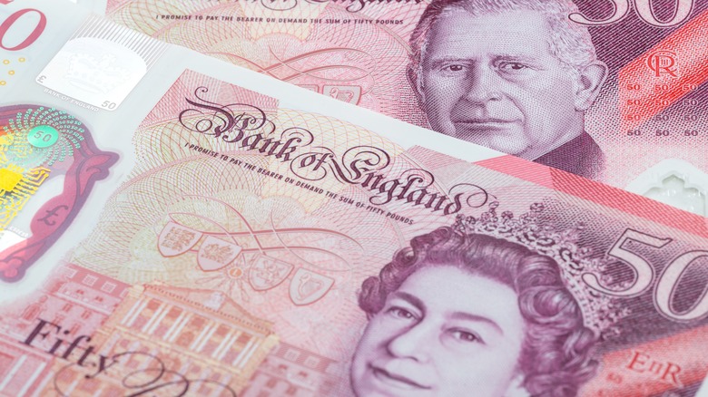 Old and new 50-pound notes lie side-by-side