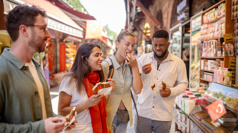 A group of friends snacking at a market