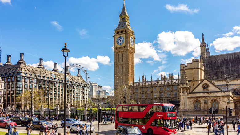 Parliament square in centre of London with Big Ben and a red bus
