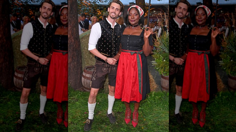Two smiling people in traditional Oktoberfest costumes