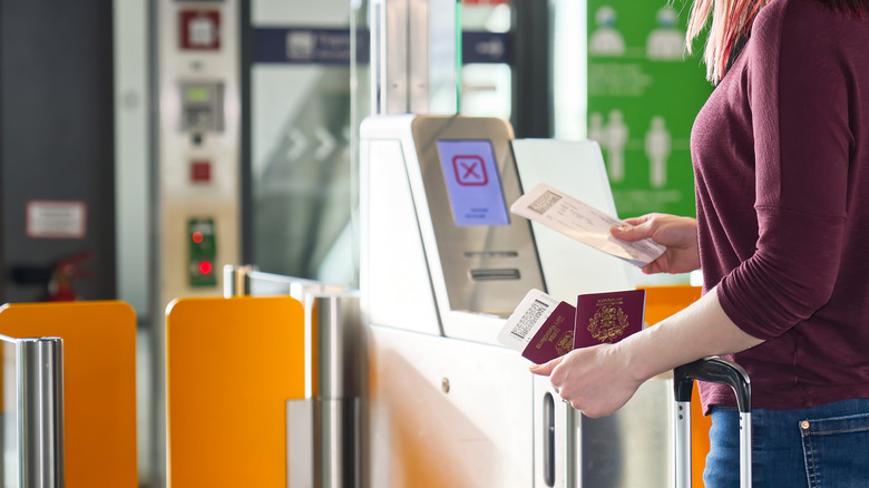 woman checking boarding pass and passport at airport