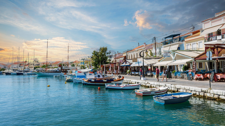A portside road lined with boats and outdoor restaurant seating