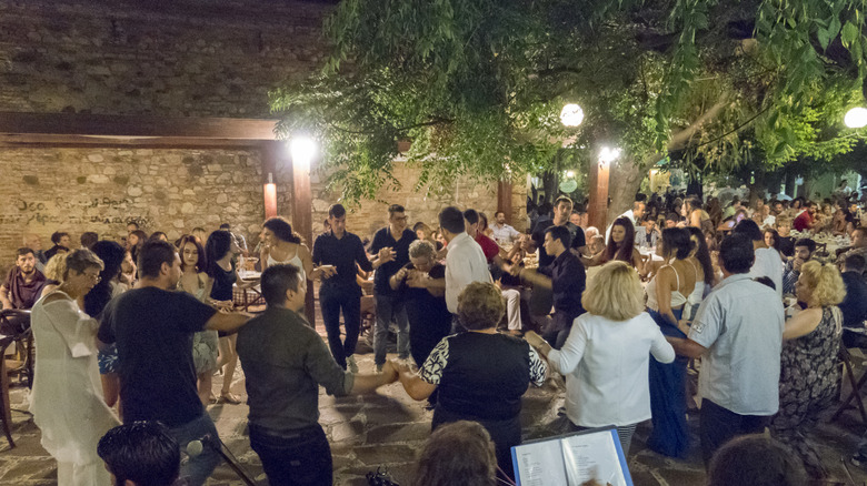Large group of people holding hands and dancing