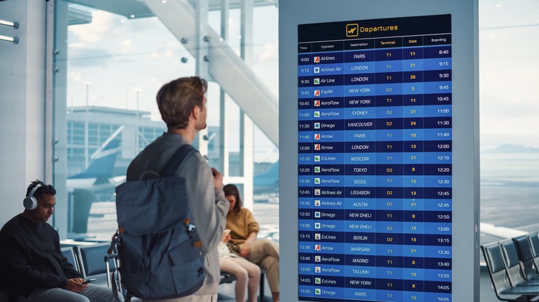 traveler looking at departure board