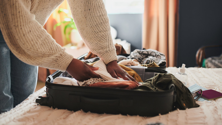 Woman packs suitcase