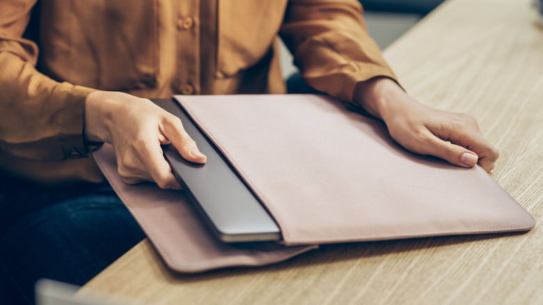 A person with a laptop and laptop sleeve